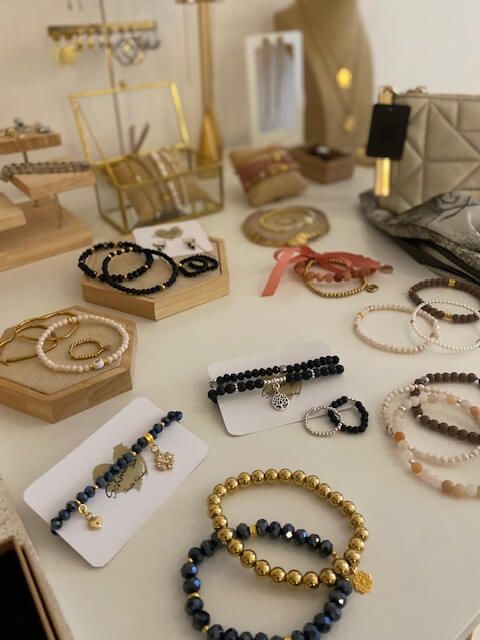 Elegante Armbänder und Schmuckstücke liegen stilvoll arrangiert in einem Kosmetikstudio neben Babor-Produkten.