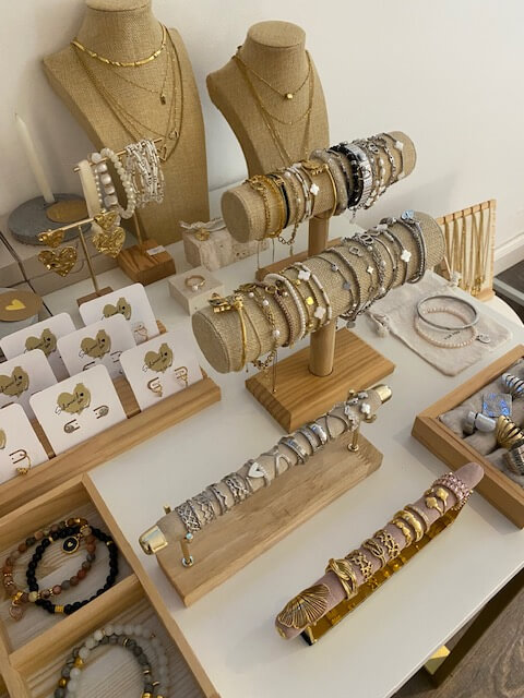 Eleganter Schmuck auf einem Tisch in einem Kosmetikstudio präsentiert Armbänder und Ketten auf stilvollen Ständern.