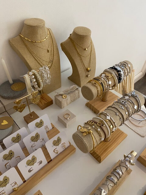 Schmuckstücke und Armbänder sind auf eleganten Ständern präsentiert und erinnern an die luxuriöse Atmosphäre eines Kosmetikstudios.